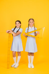 smart children at stem lesson. girls love geometry. old school. modern education. happy friends in retro uniform. vintage kid fashion. back to school. small girls hold math tools. STEM disciplines