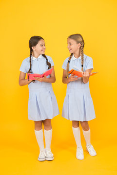Sincere interest. School library. Educational books for school. Reading books. Reading and retelling. Small children holding books yellow background. Little girls with encyclopedia or childrens books