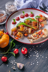 Close-up turkey flank steak, baked potatoes, asparagus, chanterelles with tomato sauce and herbs. Vertical shot