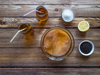 Kombucha by fermenting tea with symbiotic culture of bacteria and yeast on wooden table.  Top view. 