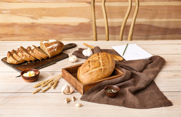 Fototapeta na wymiar Tasty fresh bread with butter and spices on white wooden table