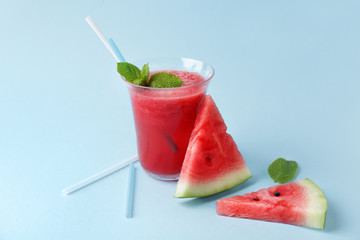Glass of fresh watermelon juice on color background