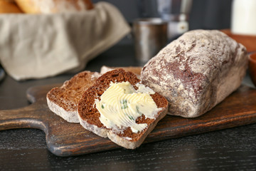 Sliced bread with butter on dark table