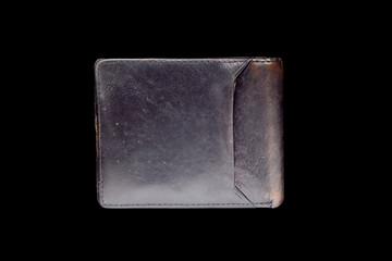 old leather wallet on a black background 