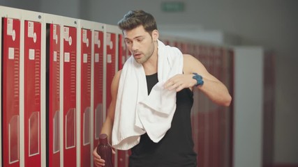 Tired man coming into dressing room after workout.