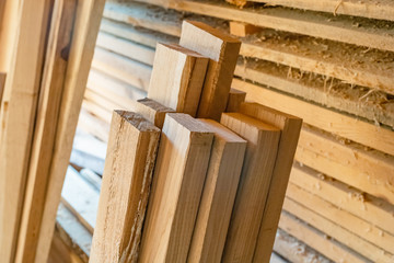 Oak wooden planks near stacked pine boards. Manual wood processing concept.