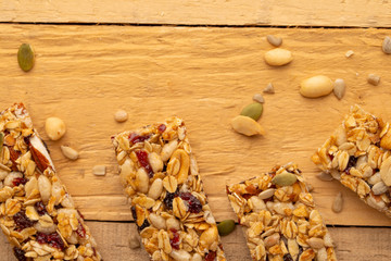 granola bars and nuts on a wooden background with space for design, horizontal photo, diet, proper...