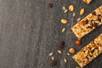 granola bars with nuts on a dark background with space for design, horizontal photo, diet, proper nutrition