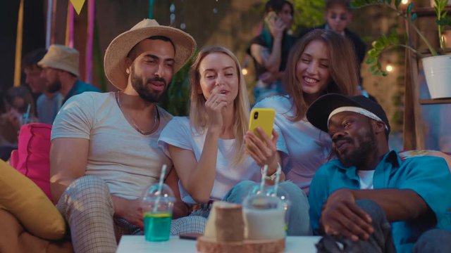 Modern youth friendly girls and guys taking group selfies posing smiling and laughing. People hangout at the party.