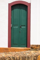 Colonial green and red door and white wall in Tiradentes city Brazil