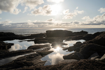 Obraz premium Felsgestein Wasser Pfütze spiegelt sonne im Himmel