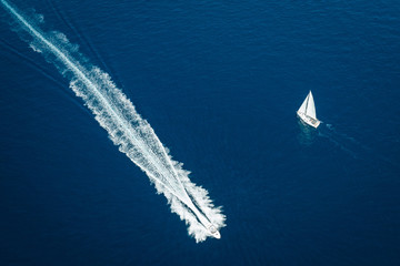 Aerial view of sailing yacht and fast motorboat