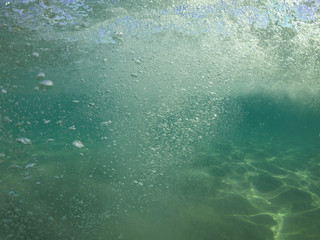 Underwater air bubbles as seen at sea rising at surface level