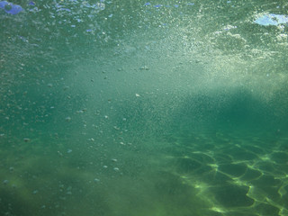 Underwater air bubbles as seen at sea rising at surface level