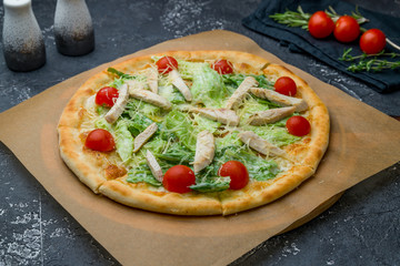 Pizza Caesar on the board on dark grey concrete table