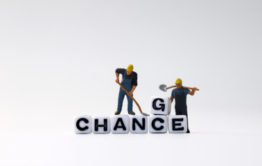 The white cube written CHANCE with miniature people.