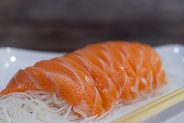 Salmon sushi nigiri and chopsticks on wooden background, Japanese style, Slices of raw salmon fillet.