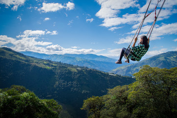 Woman on the swing of the end of the world in ambato baths. The tree house, Ecuador, Latin America