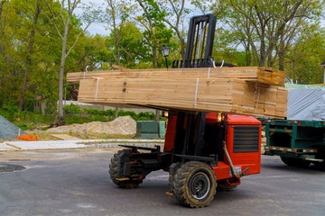 Workers in front of forklift stacker loader palette home framing beams © ungvar