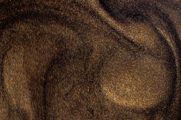 Golden glitter dust on dark background.