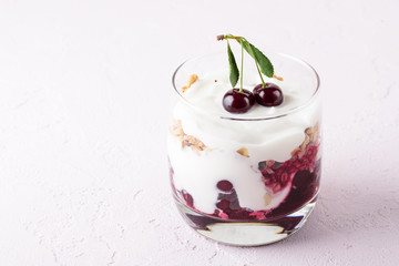 close up of dessert with cherries, granola and cottage cheese on pink background