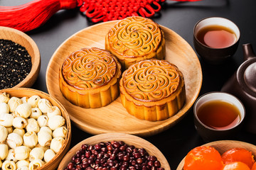 Traditional mooncakes on table setting with teacup.
