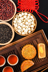 Traditional mooncakes on table setting with teacup.