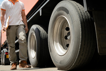 Truck Driver is Checking the Truck's Safety Maintenance Checklist. Inspection Safety of Semi Truck Wheels Tires.	