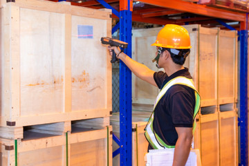 warehouse inventory management, worker hand holding barcode scanner with scanning on label of products.
