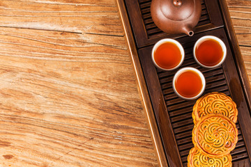 Traditional mooncakes on table setting with teacup.
