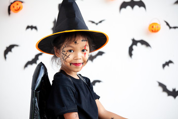 Cute asian child girl wearing halloween costumes and makeup having fun on Halloween celebration