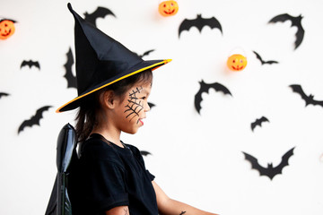 Cute asian child girl wearing halloween costumes and makeup having fun on Halloween celebration