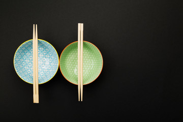 Dishes for asian food on black background. Top view, copy space