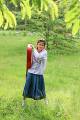 Asian school girl playing the guitar on the lawn , Student learn and practice music instruments