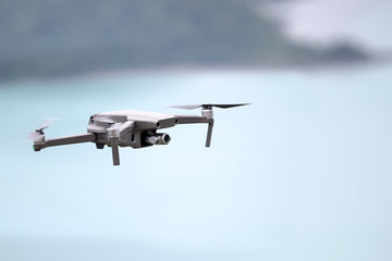 Drones while flying in the sky, Ocean and island backgrounds.