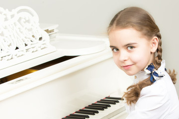 A girl from a music school plays the piano.