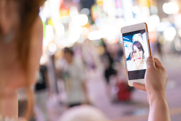 スマートフォンを操作するナイトワークの女性