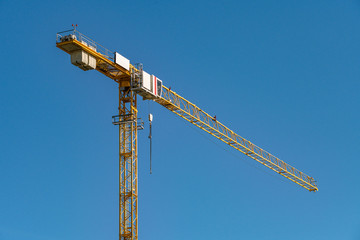 Naklejka premium concrete construction yard building site yellow crane in front of blue sky background