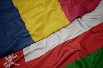 waving colorful flag of oman and national flag of chad.