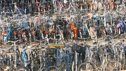 Amsterdam, Netherlands - April 21, 2019: Parking for bicycles. Many different bicycles parked on the street in special parking lots. The problem of bicycle overload in the country