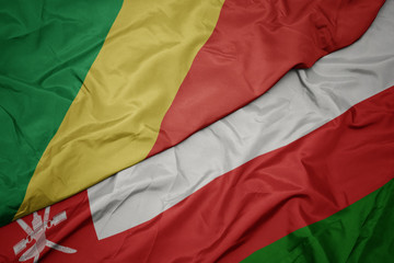 waving colorful flag of oman and national flag of republic of the congo.