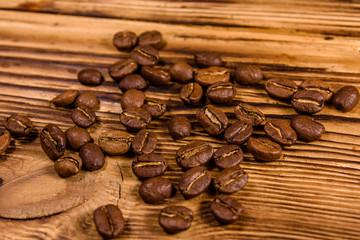 Scattered coffee beans on a wooden table