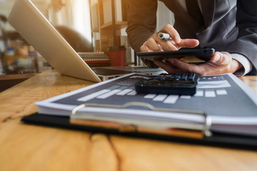 Businessman are using calculators and tablet to calculate office income.