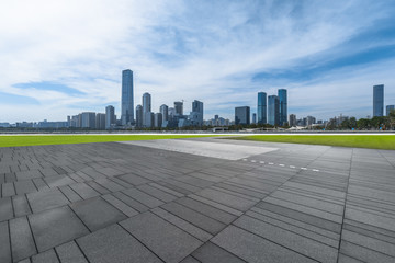 empty pavement and modern buildings in city.