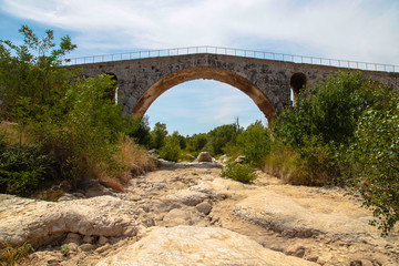 Fototapeta na wymiar Charming stone bridge across mountain river. France.