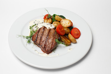 beef steak with baked potatoes and vegetables
