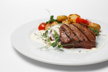 beef steak with baked potatoes and vegetables
