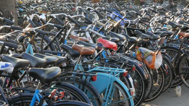 Amsterdam, Netherlands - April 21, 2019: Parking for bicycles. Many different bicycles parked on the street in special parking lots. The problem of bicycle overload in the country