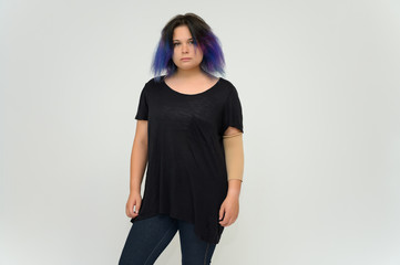 Stock Foto Portrait of a knee-deep funny cheerful girl of a young woman with multi-colored hair in a black T-shirt on a white background. In the studio, smiling, talking.