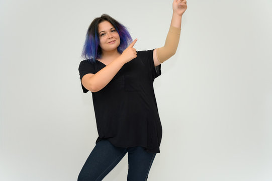 Stock Foto Portrait of a knee-deep funny cheerful girl of a young woman with multi-colored hair in a black T-shirt on a white background. In the studio, smiling, talking.